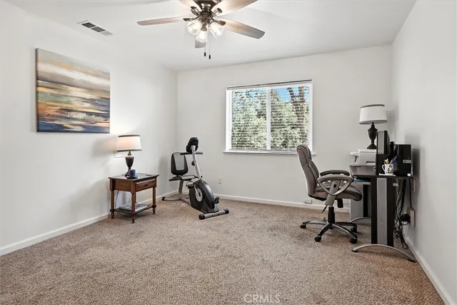 a view of a workspace with furniture and a window
