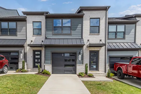 a front view of a building with a garden and plants