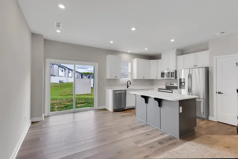 a kitchen with kitchen island a sink stainless steel appliances and cabinets