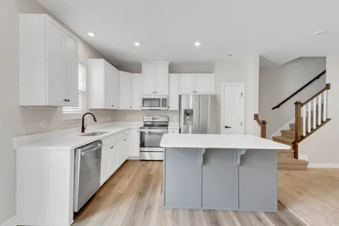 a kitchen with stainless steel appliances sink refrigerator and cabinets