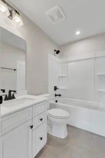 a bathroom with a double vanity sink toilet and bathtub