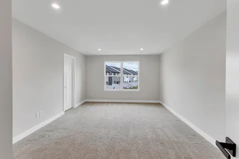an empty room with a window and cabinet