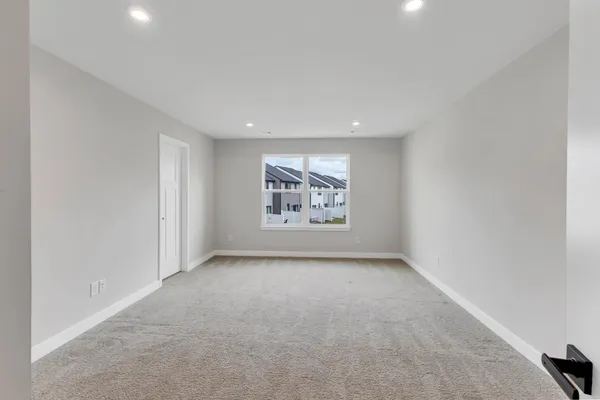 an empty room with a window and cabinet