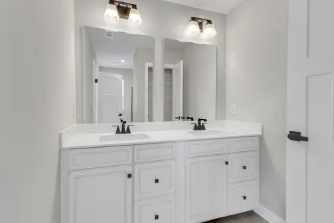 a bathroom with double sink and a mirror