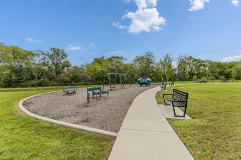 a front view of a house with a yard and potted plants