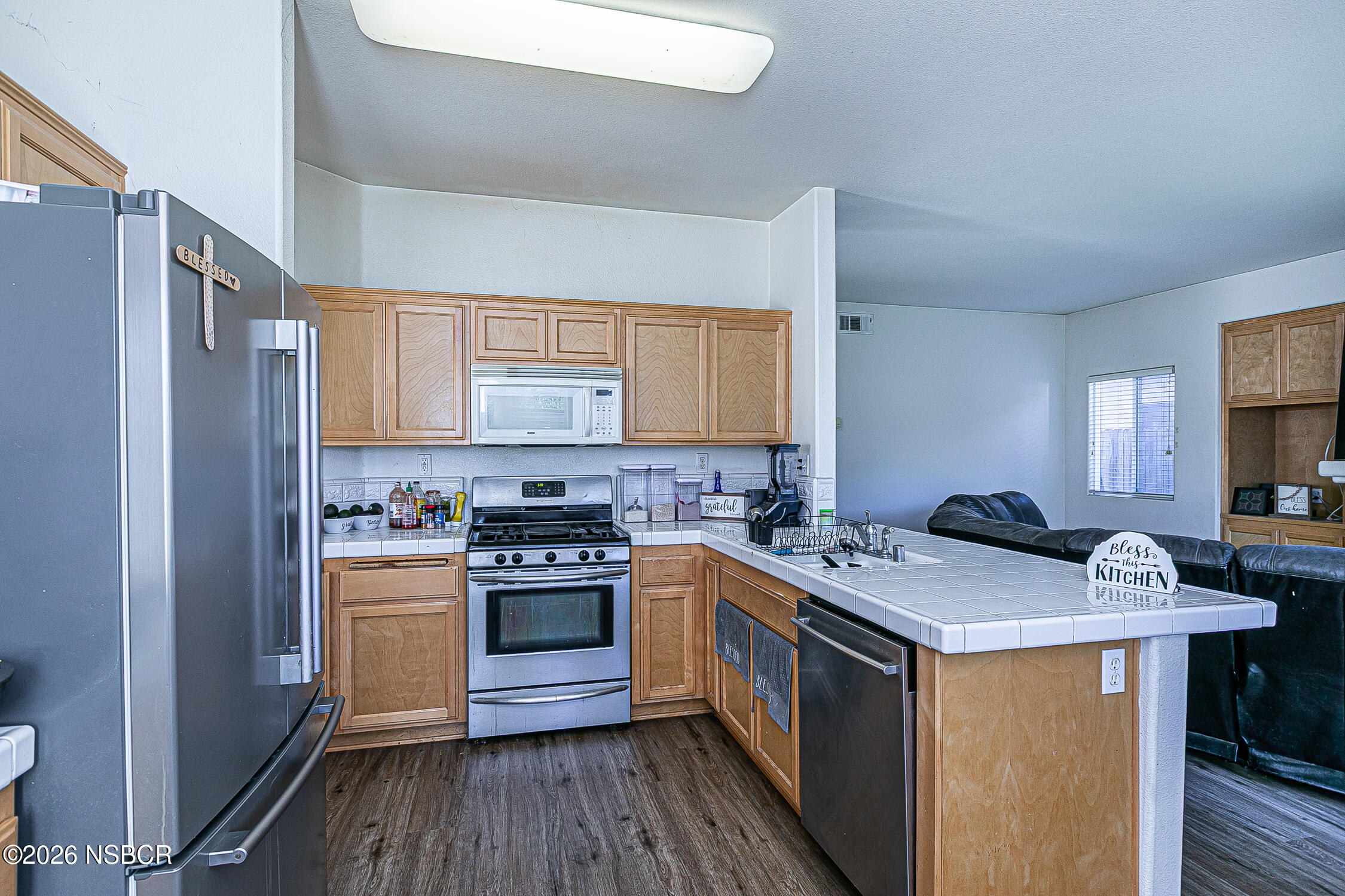1838 Gable Lane Santa Maria, CA 93458 - Photo 13 of 31 a kitchen with stainless steel appliances a stove a sink dishwasher a refrigerator white cabinets and wooden floor