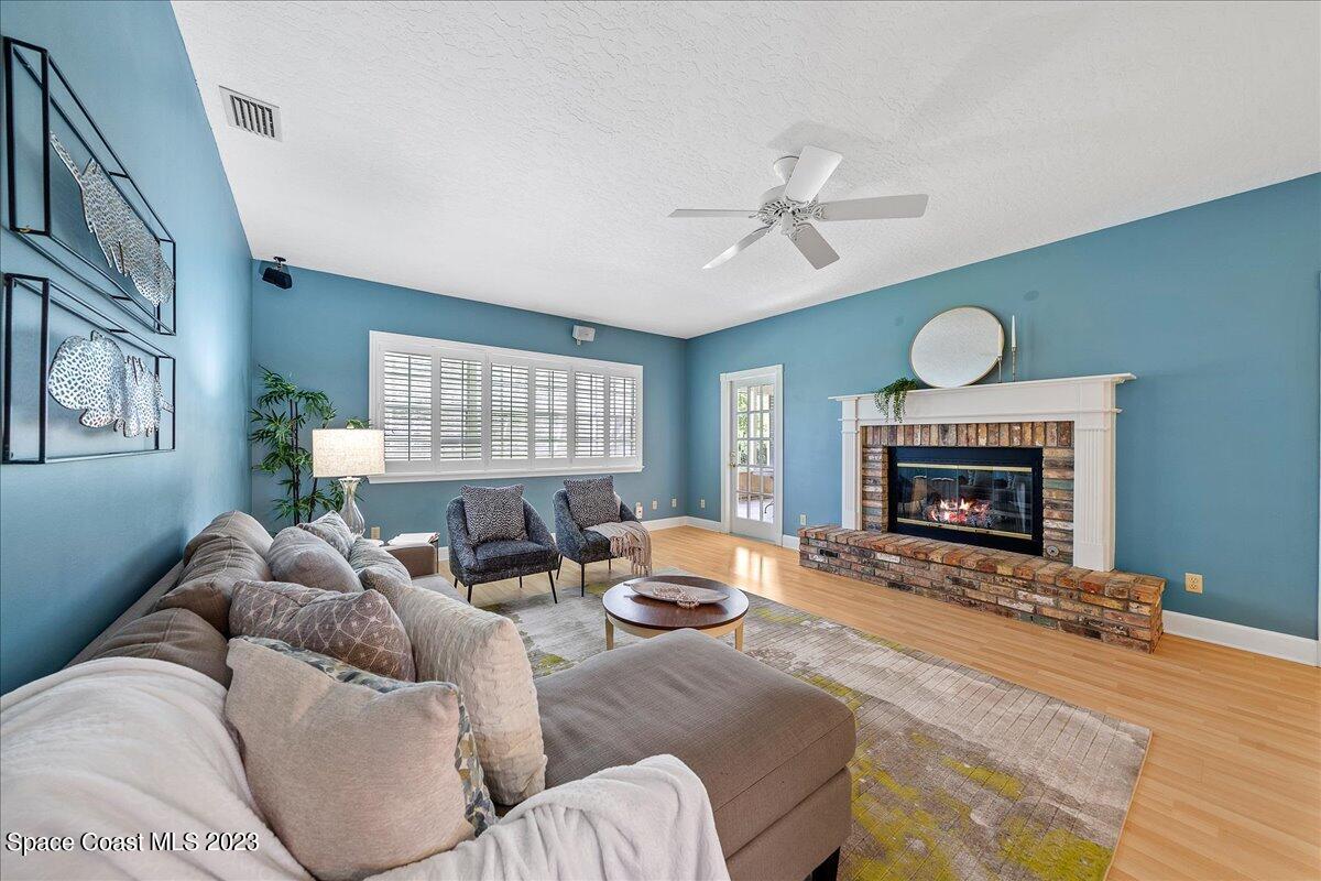 4150 Windover Way Melbourne, FL 32934 - Photo 6 of 57 a living room with furniture a fireplace and a large window