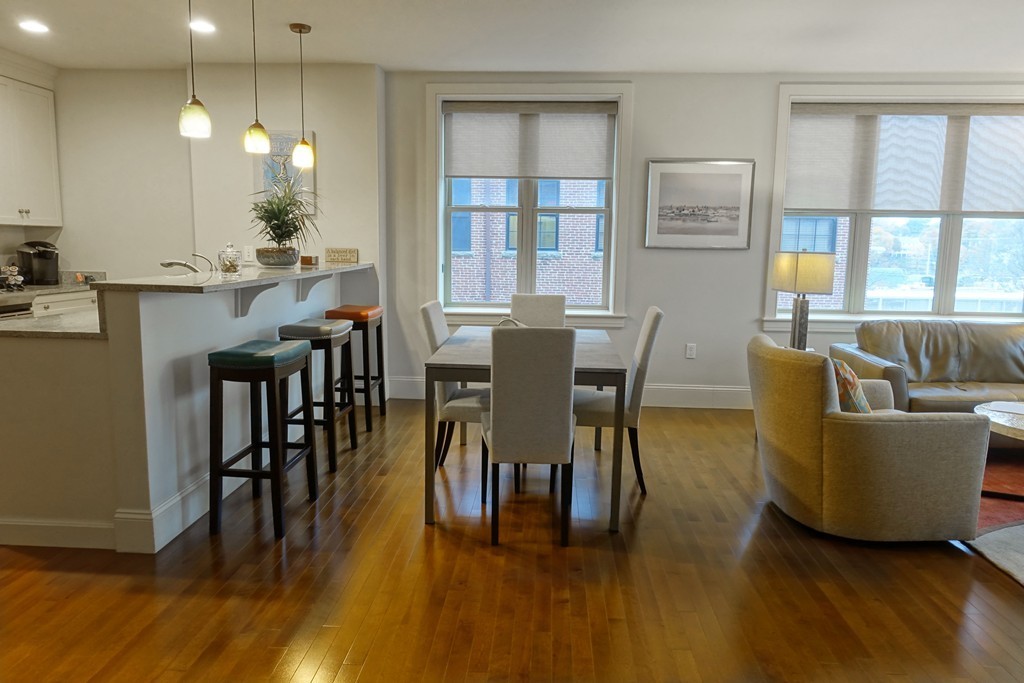 116 Rantoul Street, Unit 210 Beverly, MA 01915 - Photo 5 of 16 a view of a dining room with furniture and wooden floor