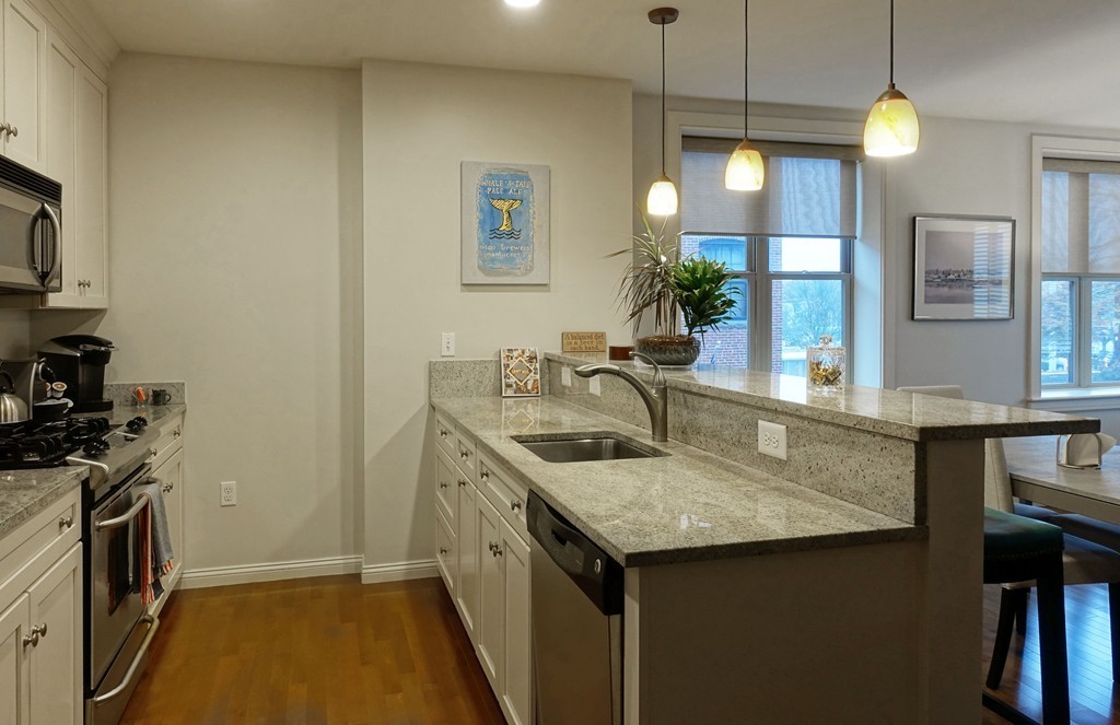 116 Rantoul Street, Unit 210 Beverly, MA 01915 - Photo 7 of 16 a kitchen with a sink a counter space and a stove