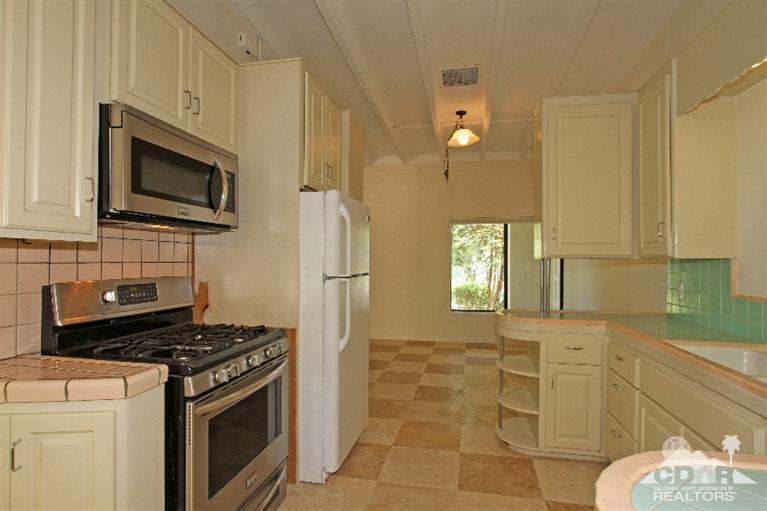 71523 Sahara Road Rancho Mirage, CA 92270 - Photo 10 of 30 a kitchen with stainless steel appliances granite countertop a stove a microwave and a refrigerator