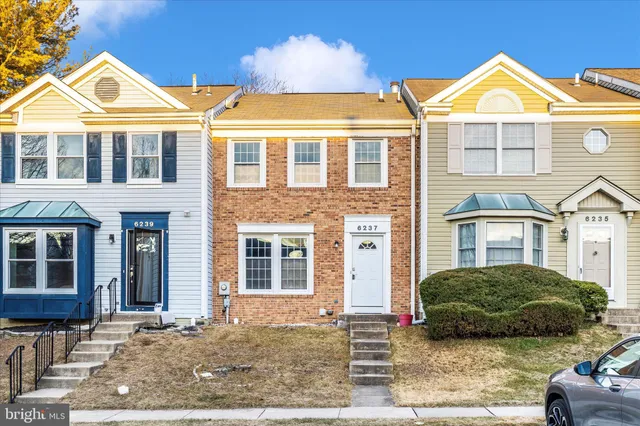 a view of a big house with a yard and plants