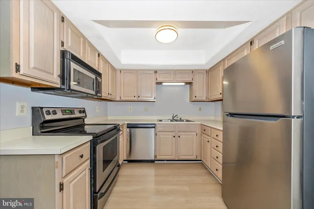 a kitchen with stainless steel appliances granite countertop a stove a refrigerator and a sink