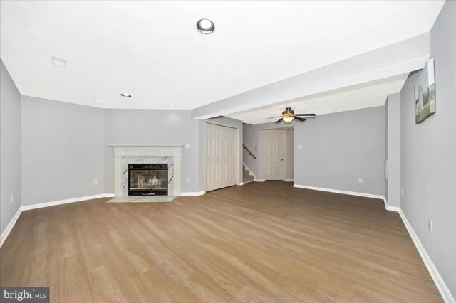 a view of empty room with wooden floor and fireplace
