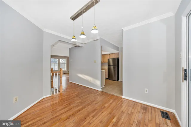 a view of a room with wooden floor and ceiling fan