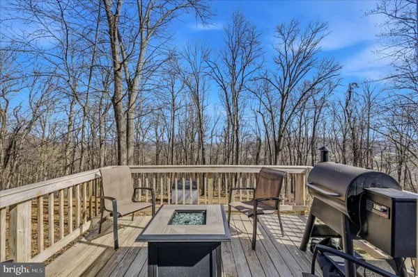 a view of a roof deck with table and chairs and wooden floor