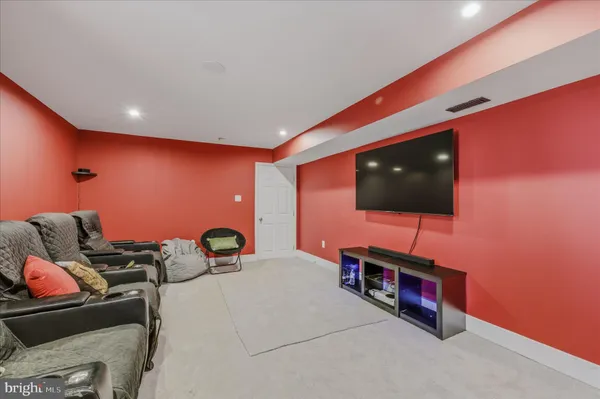 a backyard of a house with large trees and outdoor seating