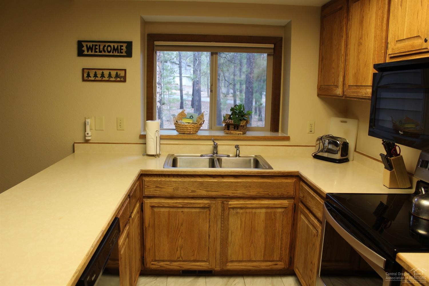 57328 Beaver Ridge Loop Sunriver, OR 97707 - Photo 7 of 22 a kitchen with a sink and cabinets