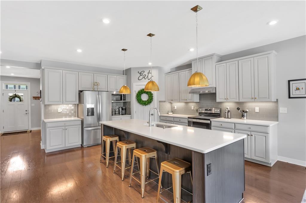 205 Regency Drive Eighty Four, PA 15330 - Photo 11 of 43 a kitchen with a sink a stove a refrigerator and chairs