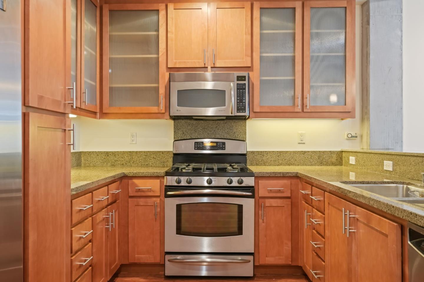 428 Alice Street, Unit 637 Oakland, CA 94607 - Photo 4 of 23 a kitchen with stainless steel appliances granite countertop a stove and a microwave