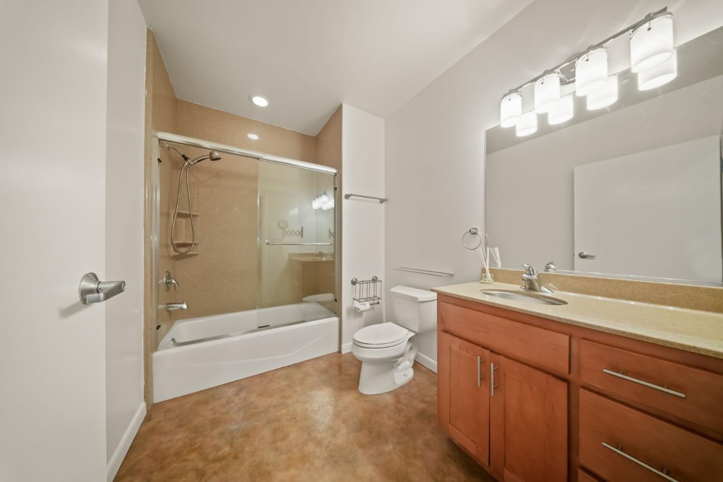 428 Alice Street, Unit 637 Oakland, CA 94607 - Photo 7 of 23 a bathroom with a granite countertop sink a toilet a mirror and shower