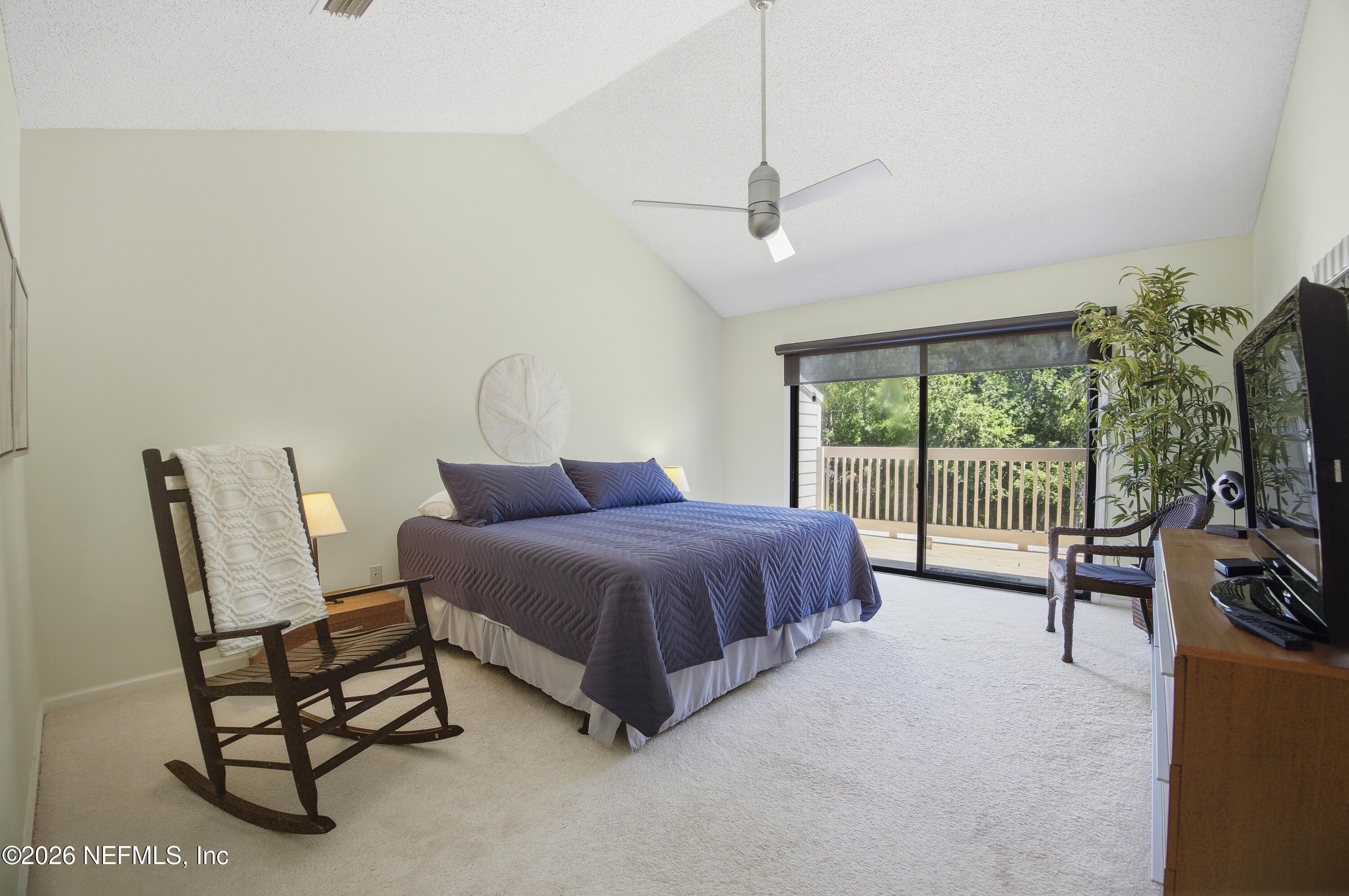 94 Players Club Villas Road Ponte Vedra Beach, FL 32082 - Photo 9 of 25 a spacious bedroom with a bed and a flat tv screen