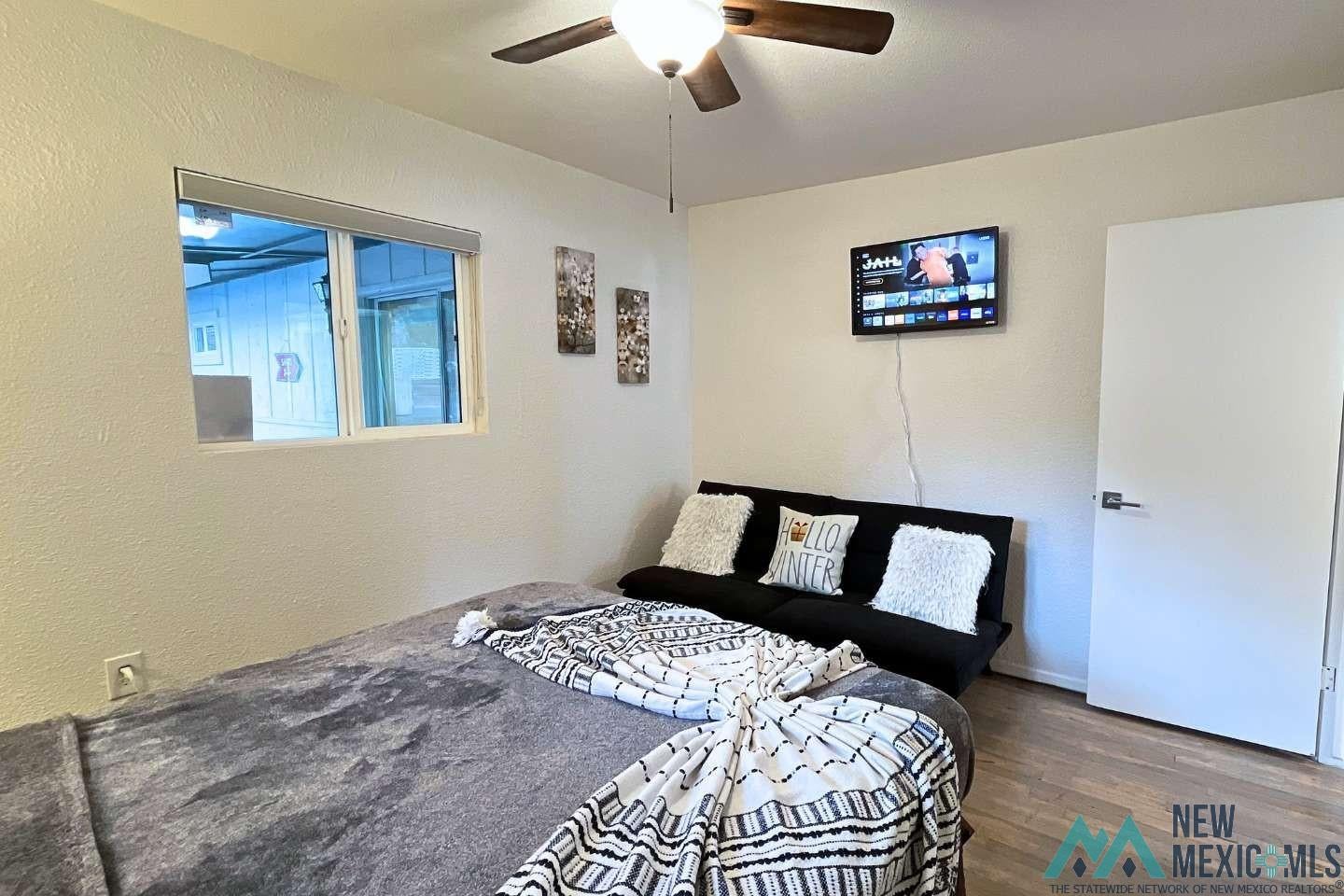 241 Junction Road Ruidoso, NM 88345 - Photo 23 of 44 Bedroom with wood finished floors, a textured wall, and ceiling fan
