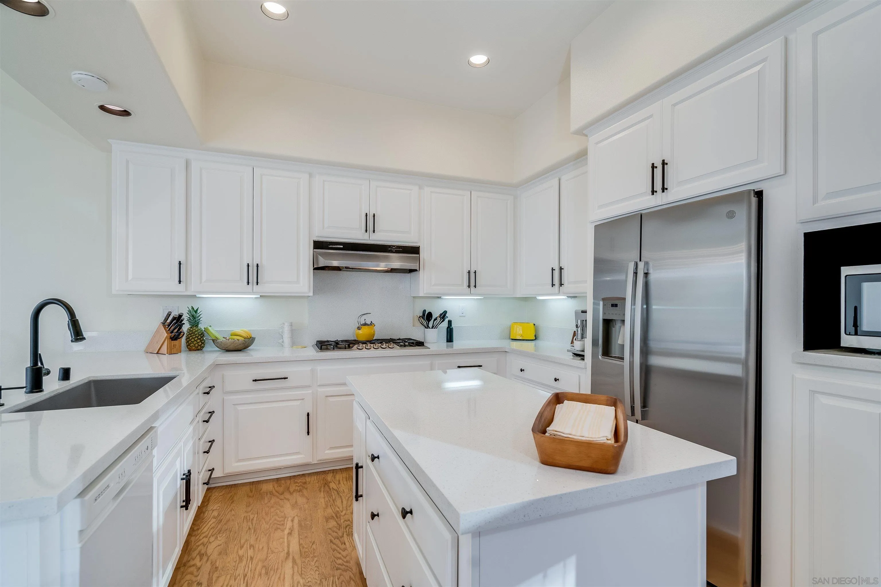 9636 Claiborne Square La Jolla, CA 92037 - Photo 21 of 48 a kitchen with stainless steel appliances a sink a stove a refrigerator a center island and cabinets