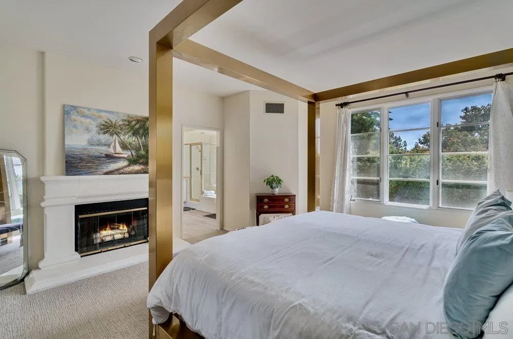 9636 Claiborne Square La Jolla, CA 92037 - Photo 26 of 48 a bedroom with a bed and a fireplace