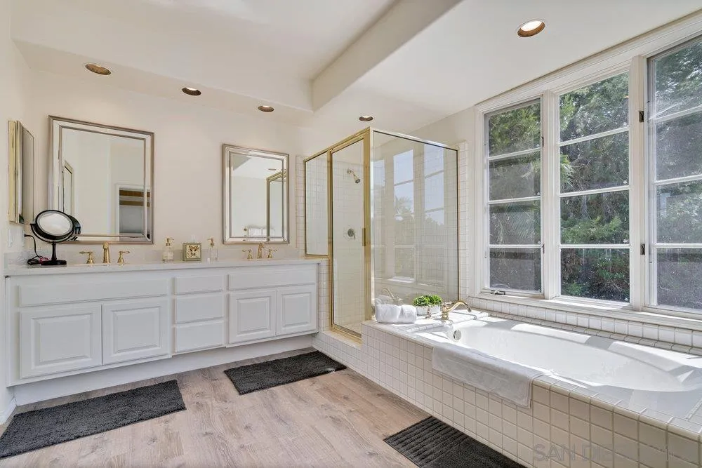 9636 Claiborne Square La Jolla, CA 92037 - Photo 27 of 48 a spacious bathroom with double vanity sinks a bathtub and a shower