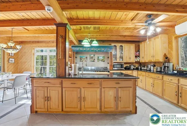 a kitchen with stainless steel appliances kitchen island granite countertop a refrigerator cabinets and wooden floors