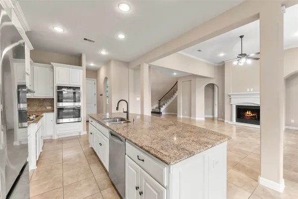 a large kitchen with stainless steel appliances granite countertop a large counter top and a stove top oven