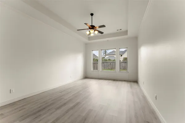 a view of a livingroom with a ceiling fan window and wooden floor