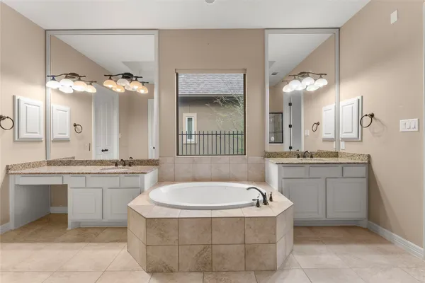 a bathroom with a granite countertop sink a large mirror and a bathtub