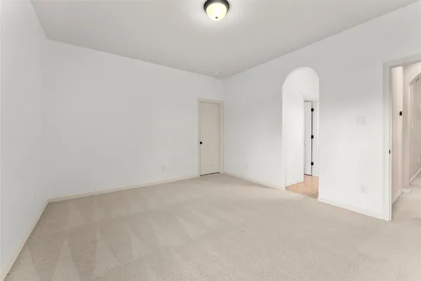 an empty room with windows and mirror