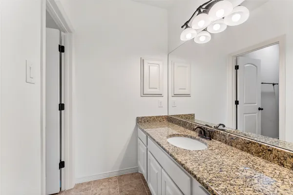 an empty room with a bathroom and mirror