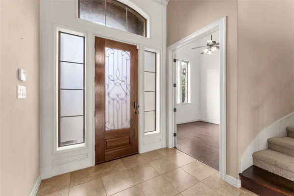 a view of a hallway with entryway and stairs