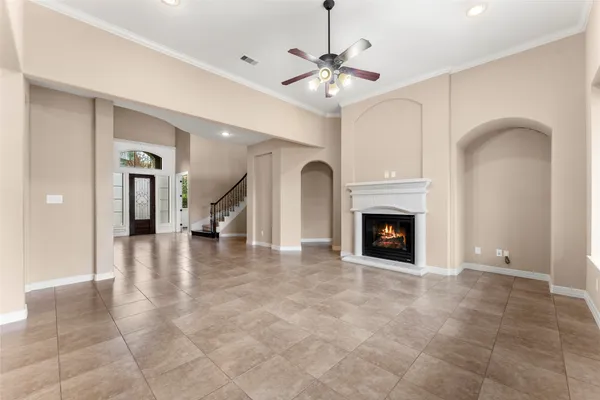 a view of a livingroom with a fireplace a chandelier and windows