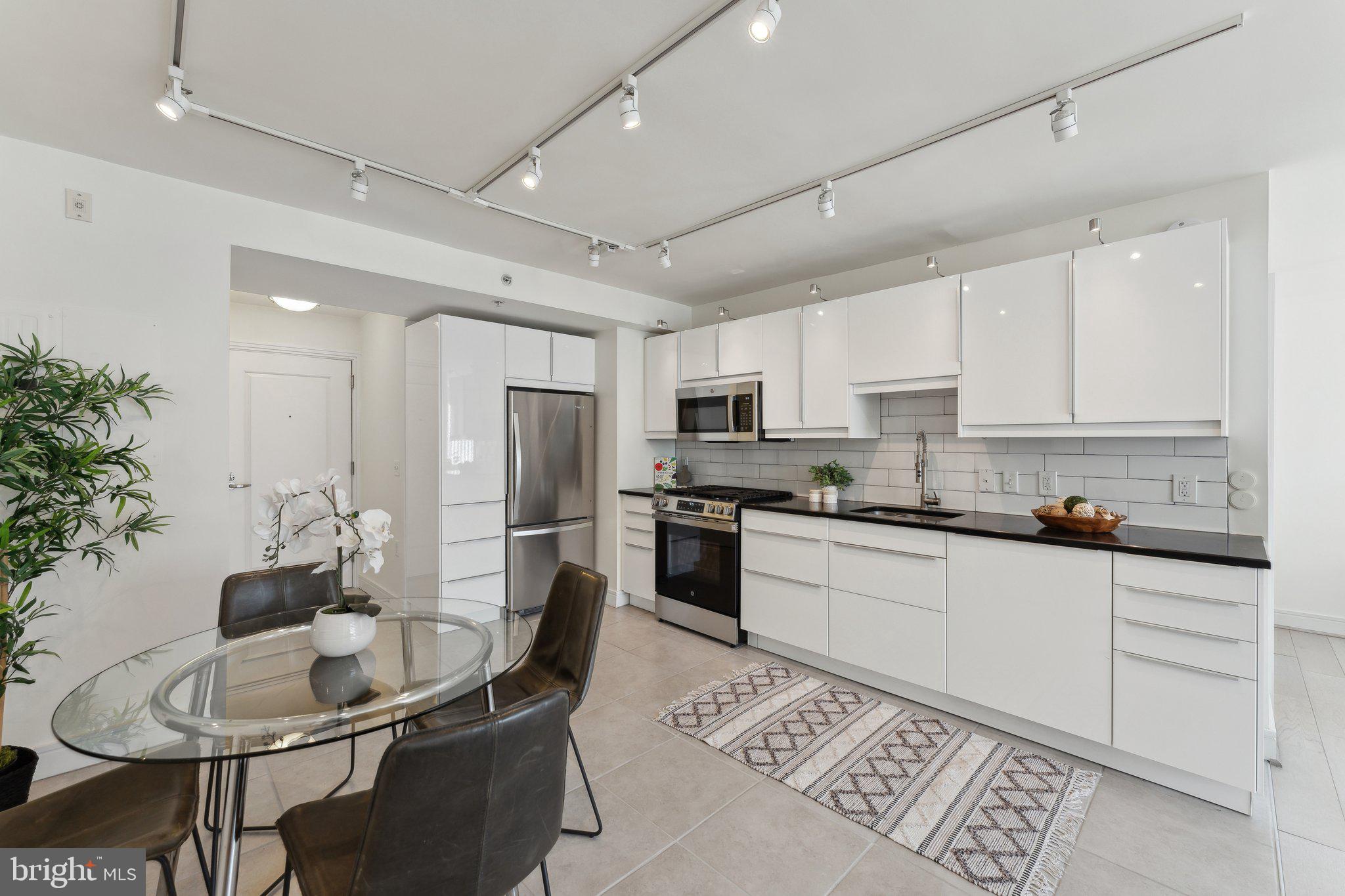800 4th Street Southwest, Unit S419 Washington, DC 20024 - Photo 13 of 32 a kitchen with white cabinets and stainless steel appliances