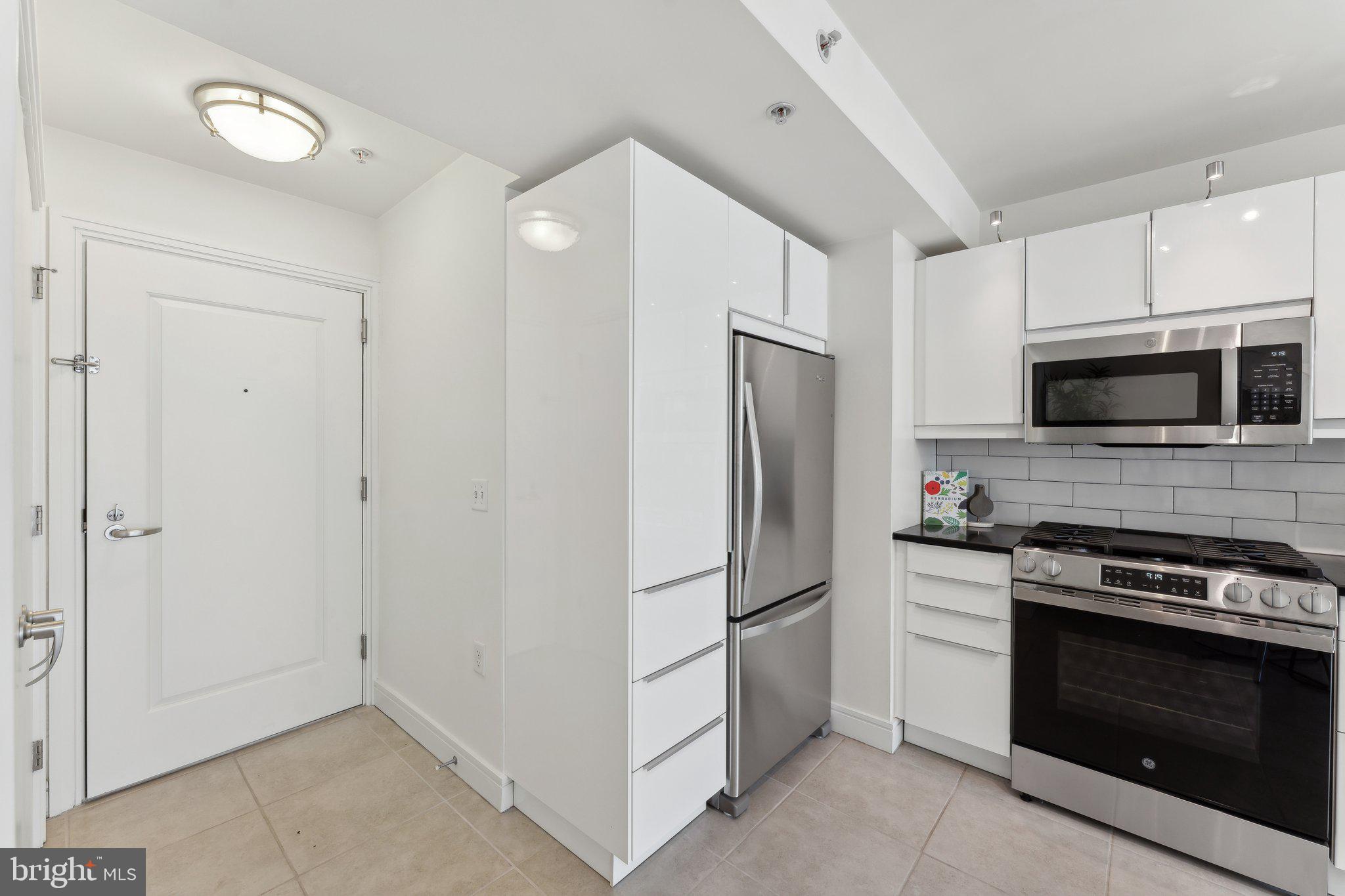 800 4th Street Southwest, Unit S419 Washington, DC 20024 - Photo 20 of 32 a kitchen with white cabinets and stainless steel appliances