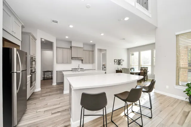 a large kitchen with kitchen island a dining table chairs and refrigerator