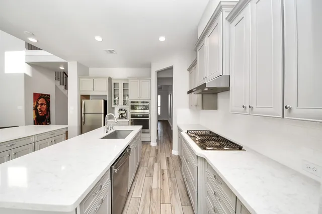 a kitchen with stainless steel appliances granite countertop a sink stove and refrigerator