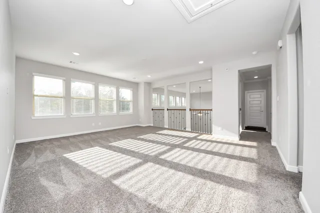 a view of an empty room with a window and kitchen