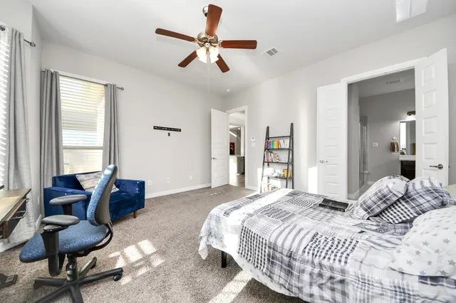 a bedroom with a bed a couch and a large window