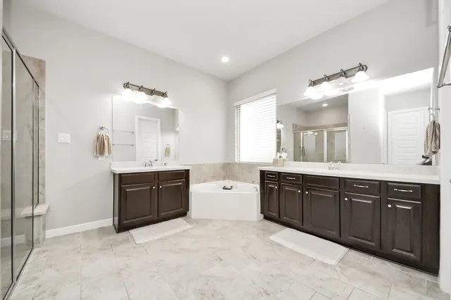 a spacious bathroom with a granite countertop double vanity sink mirror and bathtub