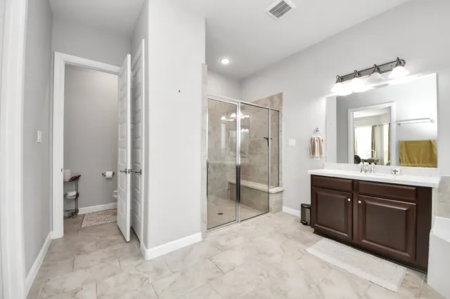 a spacious bathroom with a shower sink and mirror