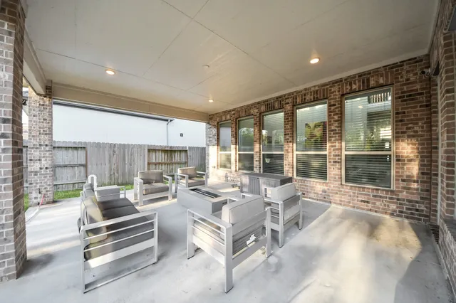 a living room with furniture large windows and a fireplace