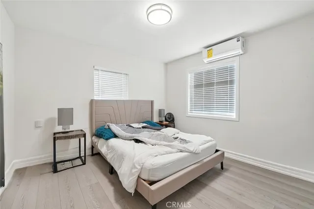 a bed sitting in a bedroom next to a window and a chair