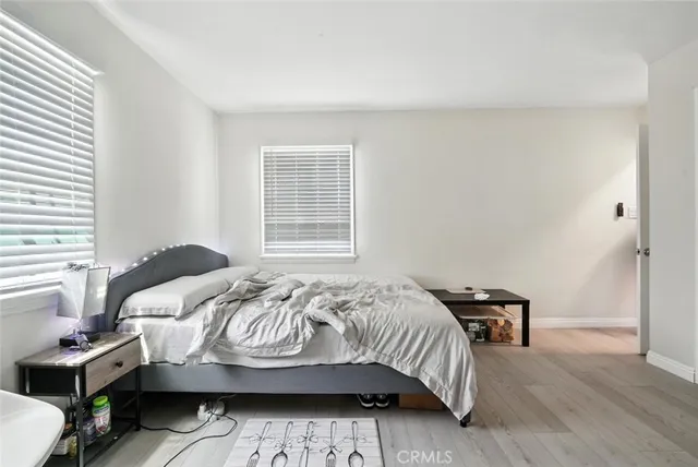 a bedroom with a bed and wooden floor
