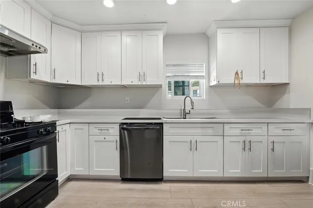 a kitchen with granite countertop white cabinets and stainless steel appliances