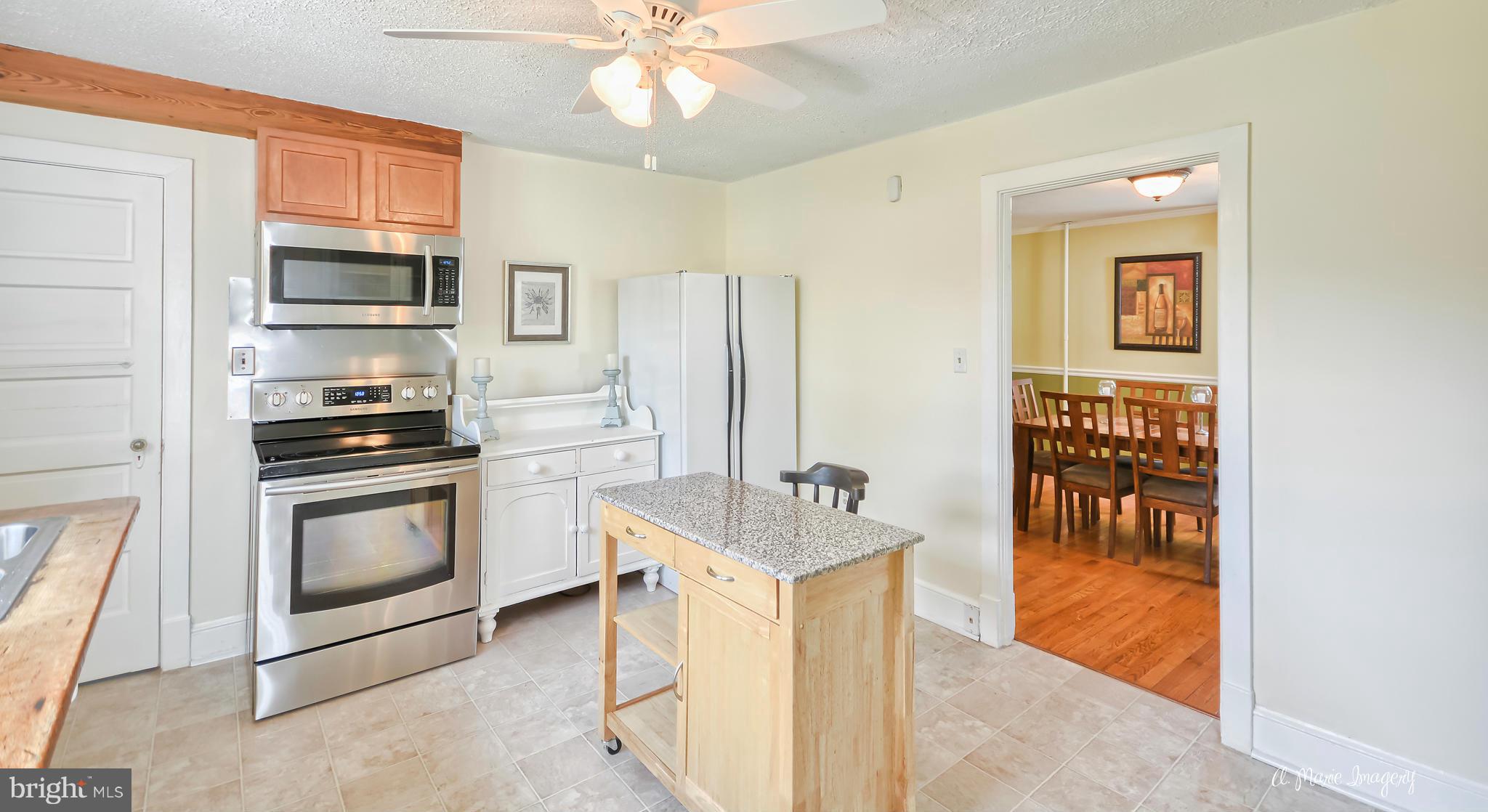 1651 Shookstown Road Frederick, MD 21702 - Photo 8 of 30 a kitchen with stainless steel appliances granite countertop a stove top oven a sink a dining table and chairs